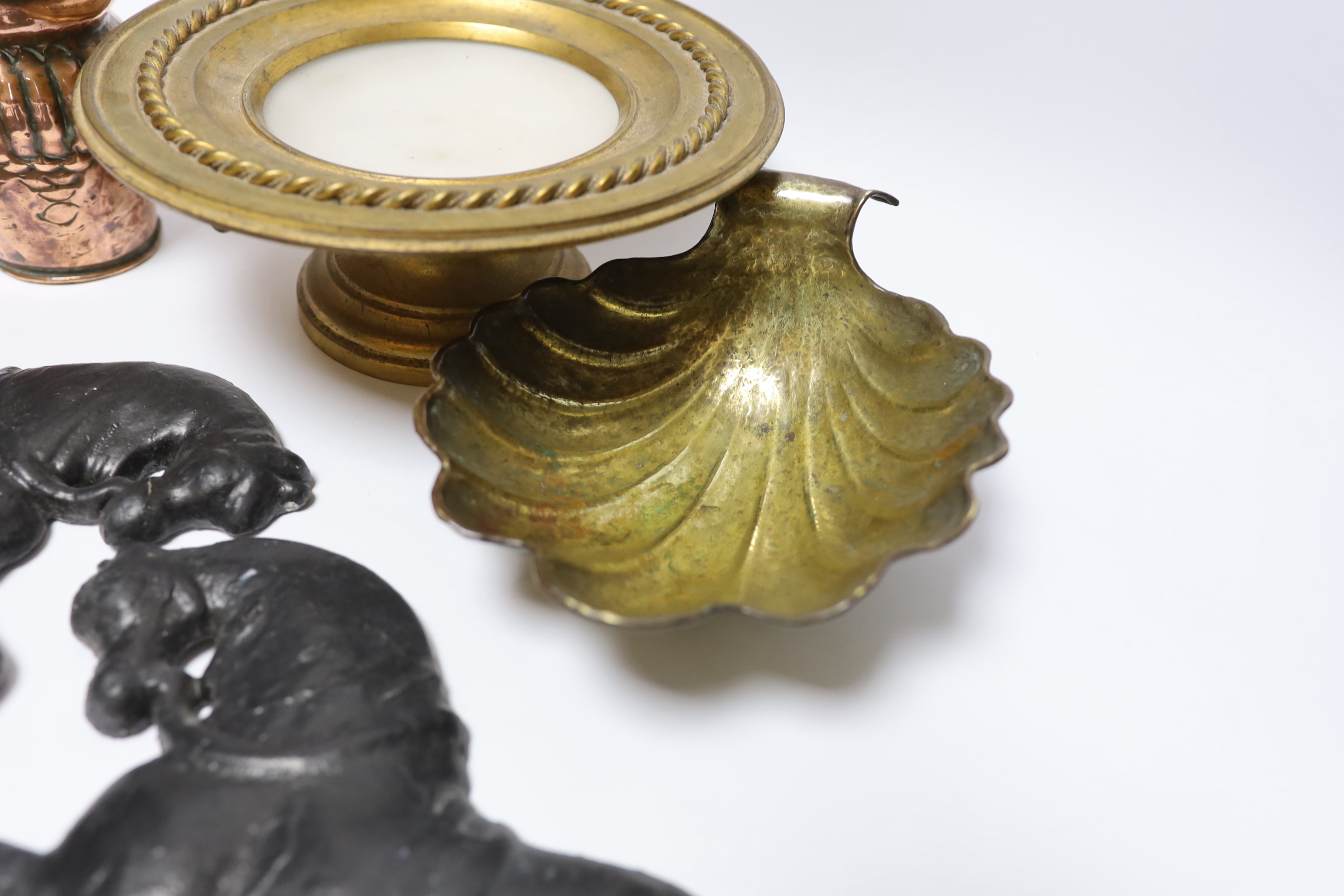 A group of metalware to include a pair of lead ‘horse’ wall mounts, a copper wall pocket, a, brass ‘scallop shell’ dish, a telescopic three pronged fork and an alabaster pedestal dish